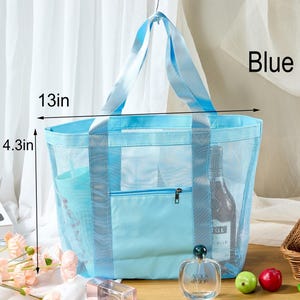 May include: A light blue mesh tote bag with a solid blue pocket and handles. The bag is 13 inches wide and 4.3 inches tall. The word "Blue" is visible on the right side of the bag.