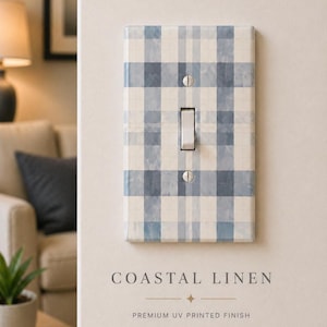 Pode incluir: Uma placa retangular para interruptor de luz com um padrão xadrez azul e branco. O interruptor é branco e a placa está montada numa parede de cor clara. O texto "COASTAL LINEN" está impresso abaixo.