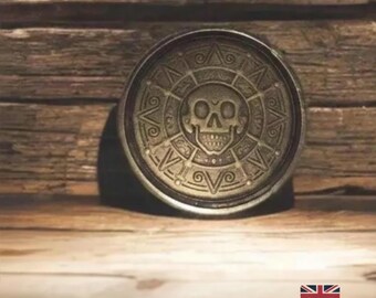 Moneda pirata azteca de latón envejecido: réplica de medallón con calavera y soporte.