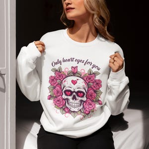May include: White sweatshirt with a pink and white skull graphic with hearts for eyes. The text "Only heart eyes for you" is printed above the skull.