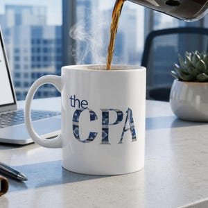 May include: A white ceramic mug with the text "the CPA" in blue patterned letters. The mug is being filled with a dark liquid, possibly coffee, with steam rising. A laptop and a succulent plant are in the background.