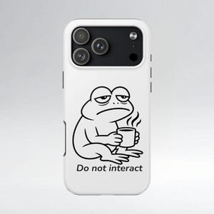 May include: White phone case featuring a black and white cartoon frog holding a coffee cup. The frog has a tired expression and the text "Do not interact" is below the frog.
