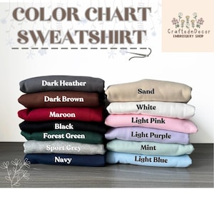 Puede incluir: Una pila de sudaderas plegadas en varios colores, incluyendo gris oscuro, granate y azul claro. La imagen muestra una carta de colores con los nombres de los colores. El texto "COLOR CHART SWEATSHIRT" est&aacute; en la parte superior, con el logo de la tienda en la esquina superior derecha.