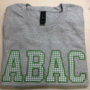 May include: A rustic wooden sign with the text "Welcome to our home" in white lettering. The sign features a distressed finish and a simple, inviting design, perfect for front door decor.