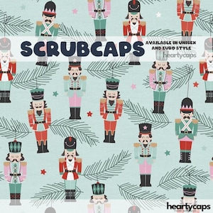 May include: A repeating pattern of colourful nutcracker figures on a light blue background, interspersed with green pine branches and red stars. The word "SCRUBCAPS" is displayed in white text across the centre of the image.