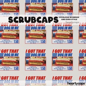 Op de afbeelding: Een herhalend patroon van "I Got That Dog In Me" afbeeldingen met een hotdog, frisdrank en prijs. Het woord "SCRUBCAPS" staat gecentreerd boven de afbeeldingen. De tekst "AVAILABLE IN UNISEX AND EURO STYLE" is ook aanwezig.