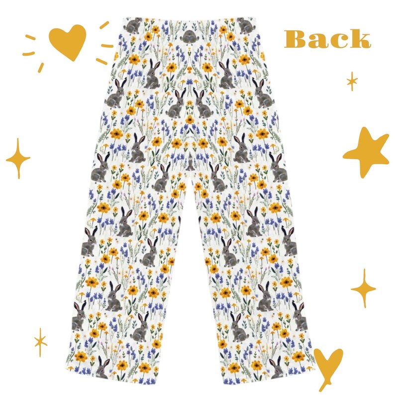May include: White pajama pants with a repeating pattern of gray rabbits, yellow flowers, and blue wildflowers. The word "Back" is printed in orange on the top right of the pants. The pants are decorated with yellow stars and hearts.
