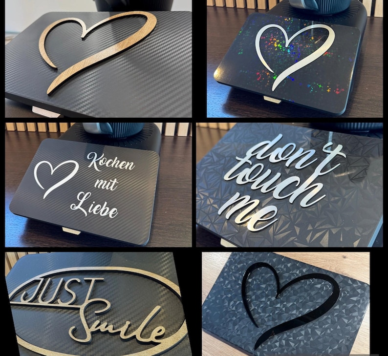May include: A collection of decorative black square plates with various designs. One features a wooden heart, another a holographic heart, and others have text like "Don't Touch Me" and "Just Smile".