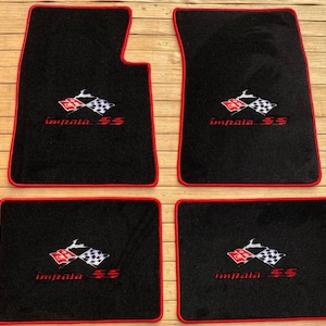 Könnte beinhalten: Ein Set aus vier schwarzen Automatten mit roter Umrandung. Jede Matte zeigt ein gesticktes Logo mit einer roten Flagge, einer Zielflagge, einer Impala-Silhouette und dem roten Schriftzug Impala SS auf der schwarzen Teppichoberfläche.