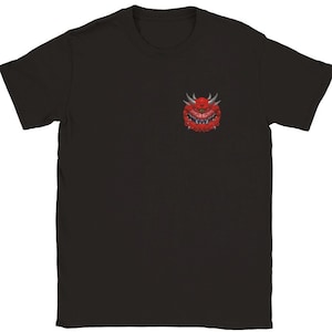 May include: Black t-shirt with a red and white demon face graphic on the front.