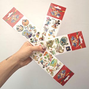 May include: Three vertical retail packaging cards featuring assorted Disney character stickers. Each card has a red header with the Mickey Kids logo. The stickers display various colorful illustrations of Mickey Mouse, Minnie Mouse, Donald Duck, and Goofy.