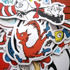 Op de afbeelding: Een verzameling kleurrijke stickers met personages uit het boek "De Kat met de Hoed" van Dr. Seuss. De stickers bevatten de Kat met de Hoed, Ding 1, Ding 2, de Vos in Sokken en de Lorax.