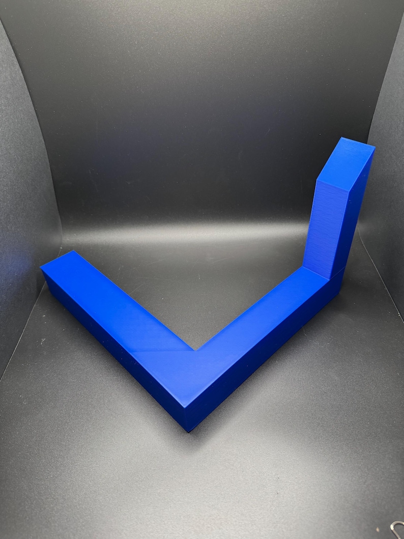 K&ouml;nnte beinhalten: Ein blaues, L-f&ouml;rmiges, geometrisches Regal aus Kunststoff. Das Regal ist f&uuml;r die Wandmontage konzipiert.