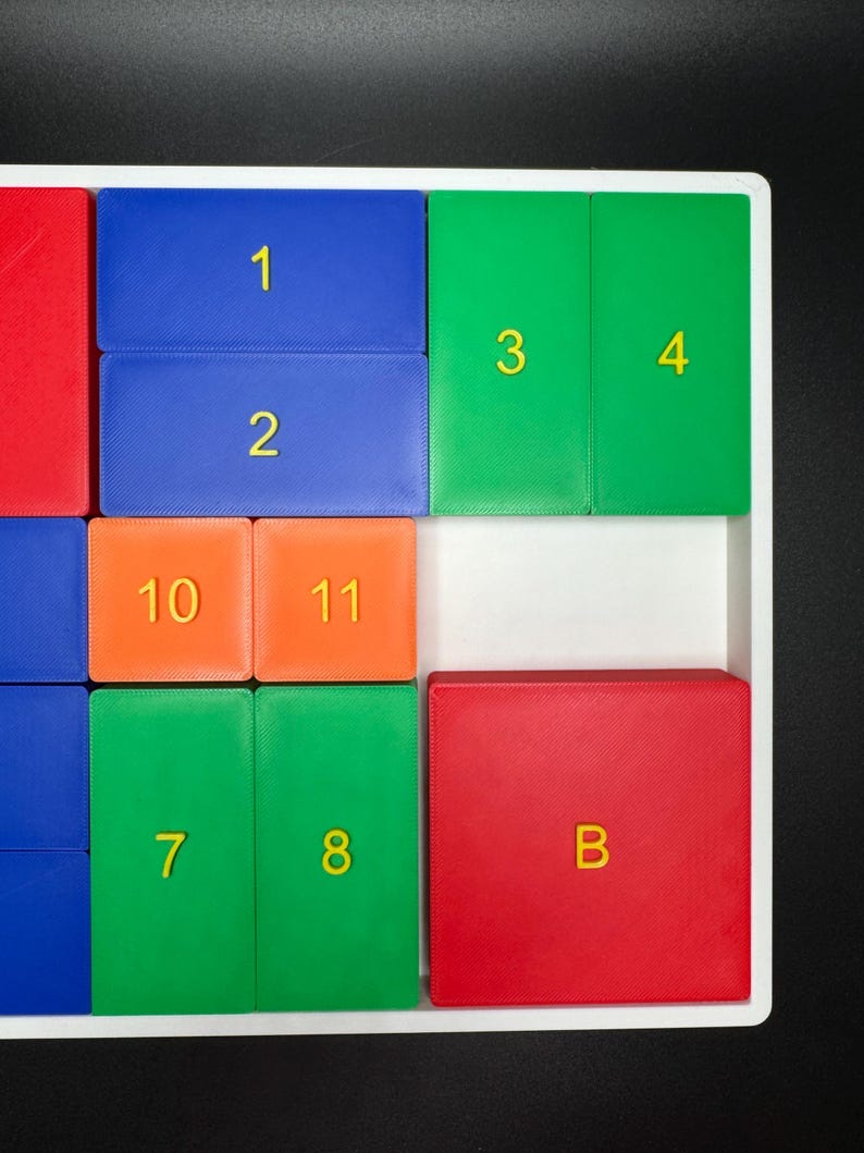 May include: A white tray with colorful tiles numbered 1 through 11 and the letter B. The tiles are arranged in a grid pattern.
