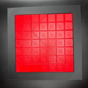K&ouml;nnte beinhalten: Ein rotes quadratisches Puzzle mit einer diagonalen Linie, die es in zwei Dreiecke teilt. Das Puzzle besteht aus kleineren Quadraten.