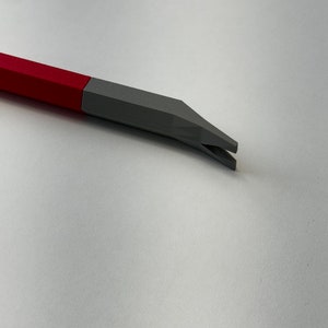 May include: A red and gray plastic tool with a pointed end and a small opening. The tool is designed for prying or lifting.