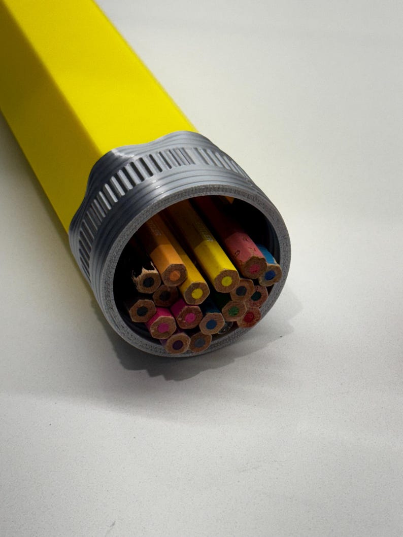 May include: A yellow pencil case with a gray cap, filled with a variety of colored pencils. The pencils are arranged in a circular pattern, with the tips of the pencils facing outwards.