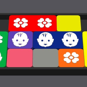 May include: A colorful game board with a variety of images, including flowers and babies. The board is made of plastic and has a black frame.