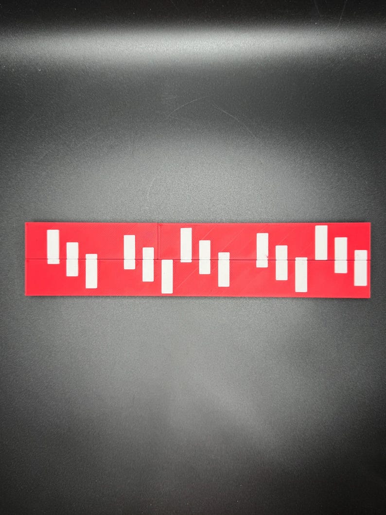 May include: A red ruler with white markings. The ruler is divided into sections with different lengths.