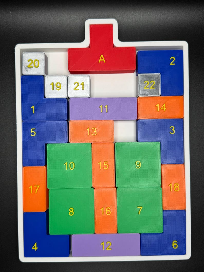 Op de afbeelding: Een wit dienblad met een rode, paarse, blauwe, groene en oranje puzzel. De puzzelstukken zijn genummerd van 1 tot 22 en gelabeld met de letter "A".