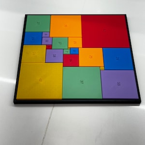 May include: A colorful square puzzle with numbers on each piece. The puzzle is made up of 16 different colored squares, each with a different number on it. The numbers range from 4 to 50.