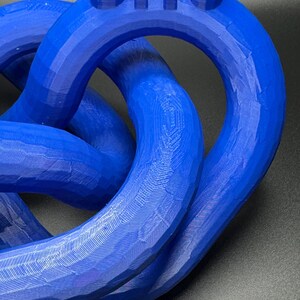 May include: A blue 3D printed knot sculpture with the number "819" printed on the top.