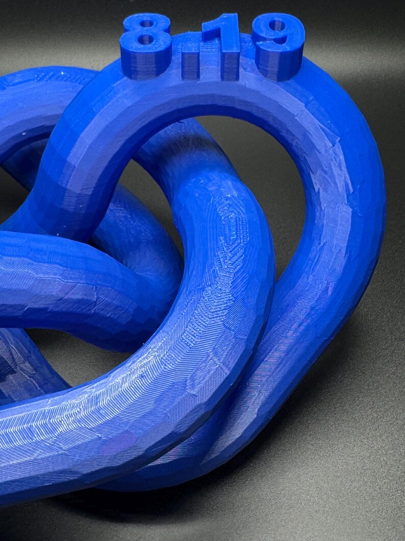 May include: A blue 3D printed knot sculpture with the number "819" printed on the top.