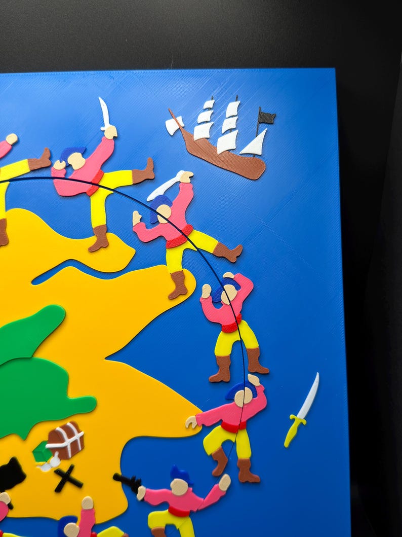 May include: A colorful, 3D-printed pirate-themed artwork. The piece features a blue background with a yellow and green landmass. Figures in pink shirts and yellow pants are depicted with weapons, a treasure chest, and a ship.
