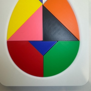 Op de afbeelding: Een ronde puzzel met acht stukken in verschillende kleuren: geel, roze, rood, groen, blauw, zwart, oranje en paars. De stukken passen in elkaar om een cirkel te vormen.