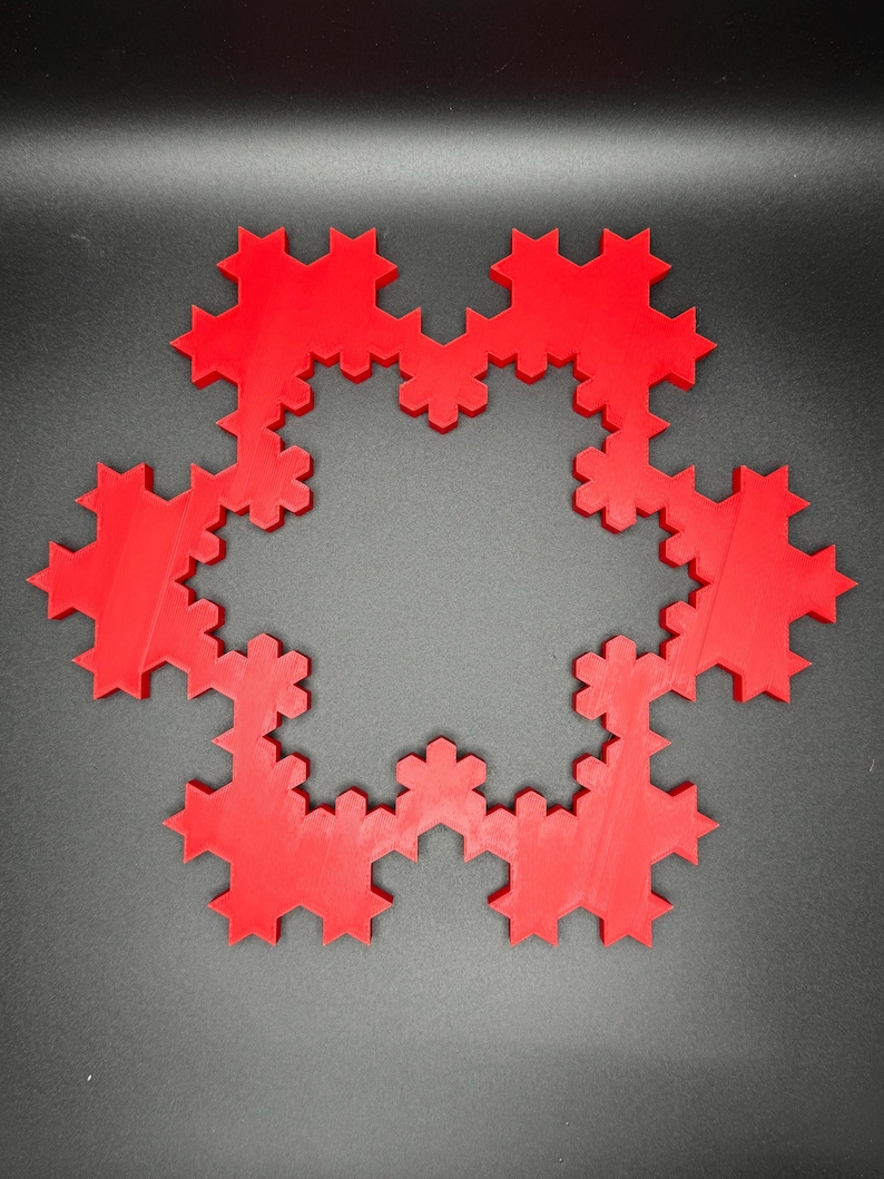 May include: A red, 3D printed snowflake design with a circular shape and a detailed, intricate pattern.