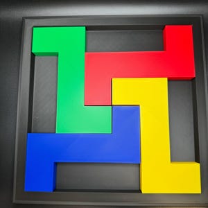 Op de afbeelding: Een kleurrijke puzzel met in elkaar grijpende geometrische vormen in groen, rood, geel en blauw. De stukken zijn gerangschikt in een zwart frame, wat een visueel aantrekkelijk ontwerp cre&euml;ert. De vormen zijn blokkerig en hoekig.