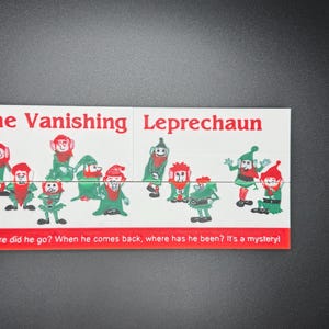 May include: A white card with the text "The Vanishing Leprechaun" and a picture of nine green leprechauns with red hats. The text "Where did he go? When he comes back, where has he been? It's a mystery!" is at the bottom of the card.