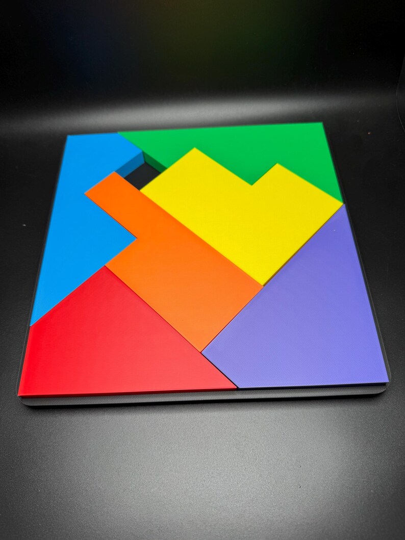 May include: A colorful geometric puzzle made of six pieces. The pieces are arranged in a square shape and are in the colors red, orange, yellow, green, blue, and purple.