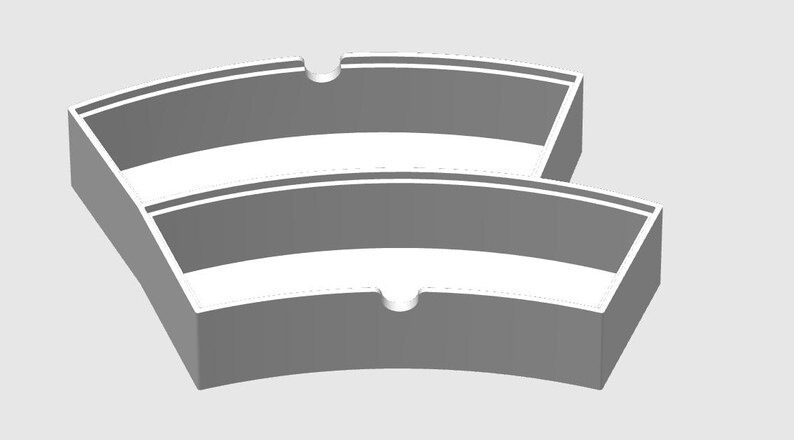 May include: A gray ashtray with a curved design. The ashtray has a white stripe and a small indentation for resting cigarettes. The design is modern and minimalist.
