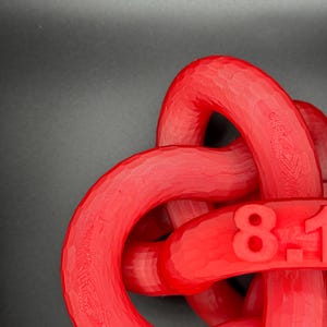 May include: A red plastic knot with the numbers "81" printed on it.