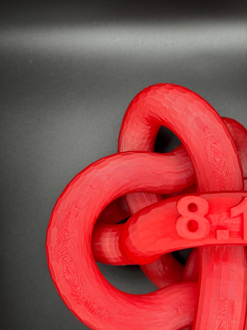 May include: A red plastic knot with the numbers "81" printed on it.