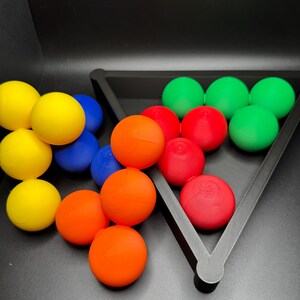 Peut inclure: Un ensemble de boules color&eacute;es dans un plateau triangulaire. Les boules sont rouges, vertes, bleues et jaunes. Le plateau est noir et a une forme triangulaire.