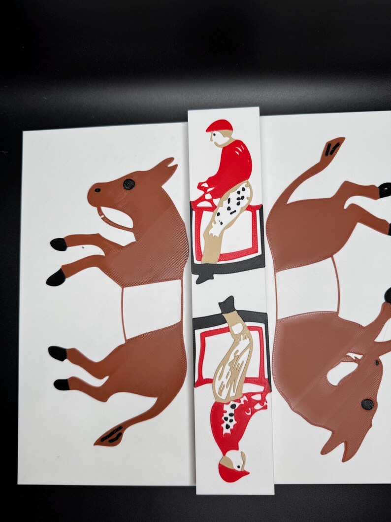 May include: Two brown donkey figures with a red and white jockey riding each one. The figures are cut out and ready to be assembled.