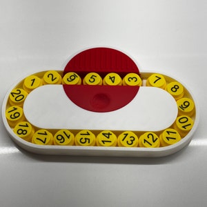 May include: A white plastic circular puzzle with a red center and yellow numbered pieces. The numbers 1 through 20 are displayed on the yellow pieces.