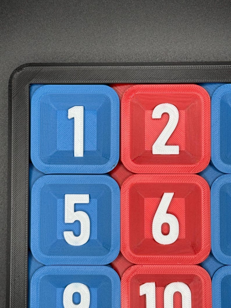 Pu&ograve; includere: Primo piano di una scacchiera con caselle blu e rosse. Ogni casella ha un numero bianco. I numeri sono 1, 2, 5, 6, 9 e 10.
