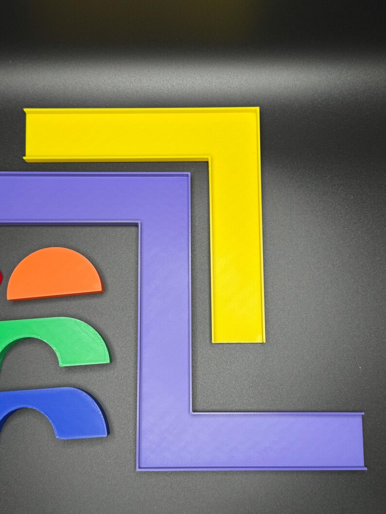 May include: Two L-shaped pieces of plastic, one yellow and one purple, are stacked on top of each other. Three semi-circular pieces of plastic, one orange, one green, and one blue, are arranged below the L-shaped pieces.