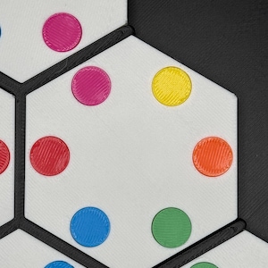 May include: A white hexagonal game board with black lines and colorful circles. The circles are red, pink, yellow, blue, and green.