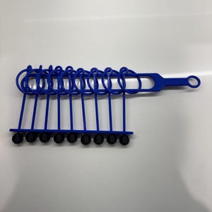 Pode incluir: Um conjunto de an&eacute;is de pl&aacute;stico azul com pontas de borracha preta, presos a uma al&ccedil;a de pl&aacute;stico azul. Os an&eacute;is s&atilde;o projetados para organizar e armazenar itens.