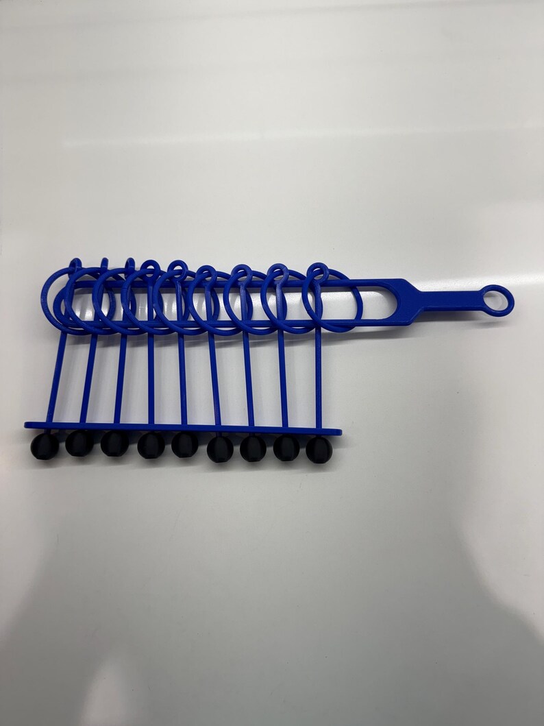 Pode incluir: Um conjunto de an&eacute;is de pl&aacute;stico azul com pontas de borracha preta, presos a uma al&ccedil;a de pl&aacute;stico azul. Os an&eacute;is s&atilde;o projetados para organizar e armazenar itens.
