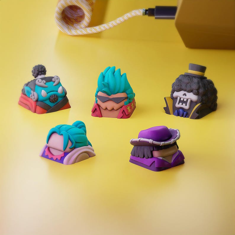 May include: Five colorful keycaps featuring characters from the anime One Piece. The keycaps are made of plastic and have a variety of colors, including green, blue, red, purple, and black. The keycaps are designed to fit standard mechanical keyboards.