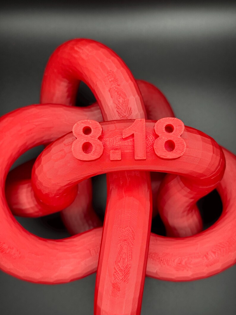 May include: A red plastic knot with the number "818" printed on it.