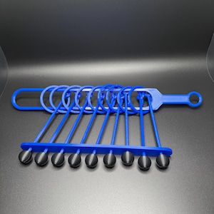 Pode incluir: Um conjunto de an&eacute;is de pl&aacute;stico azul com pontas de borracha preta. Os an&eacute;is est&atilde;o conectados a uma al&ccedil;a de pl&aacute;stico azul.