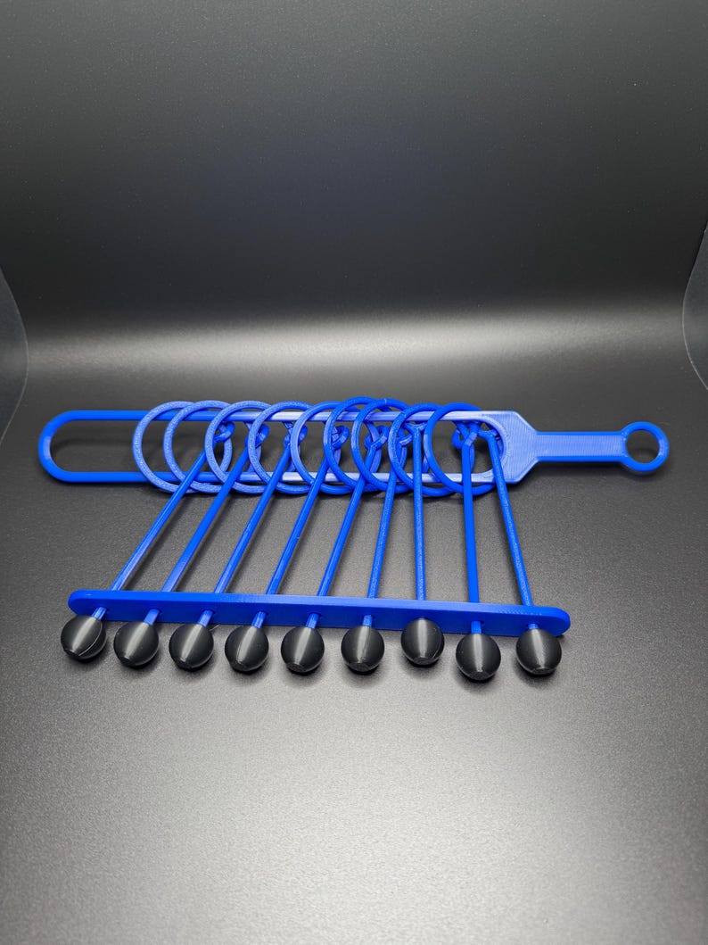 Pode incluir: Um conjunto de an&eacute;is de pl&aacute;stico azul com pontas de borracha preta. Os an&eacute;is est&atilde;o conectados a uma al&ccedil;a de pl&aacute;stico azul.