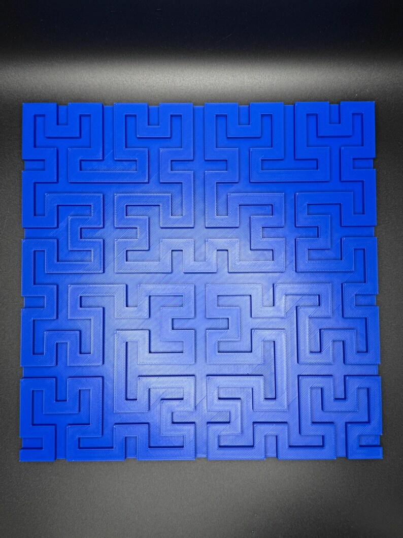 Op de afbeelding: Een blauwe plastic doolhof met een complex patroon van in elkaar grijpende paden. De doolhof is ontworpen om uitdagend en leuk te zijn om op te lossen.