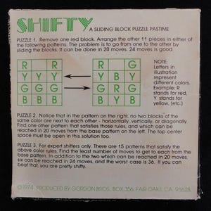May include: A vintage game called "Shifty" with instructions for a sliding block puzzle. The game involves arranging colored blocks in a grid pattern. The instructions explain the rules and challenges of the game.
